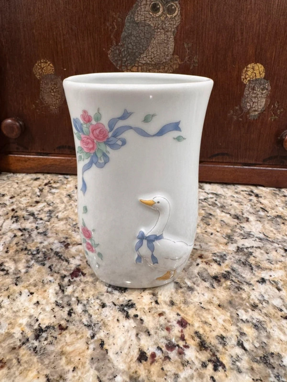 Vintage white goose vase with flowers and ribbon